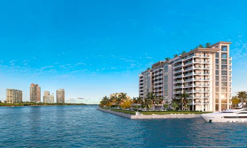 Waterfront high-rise condos beside a calm blue bay under a clear sky
