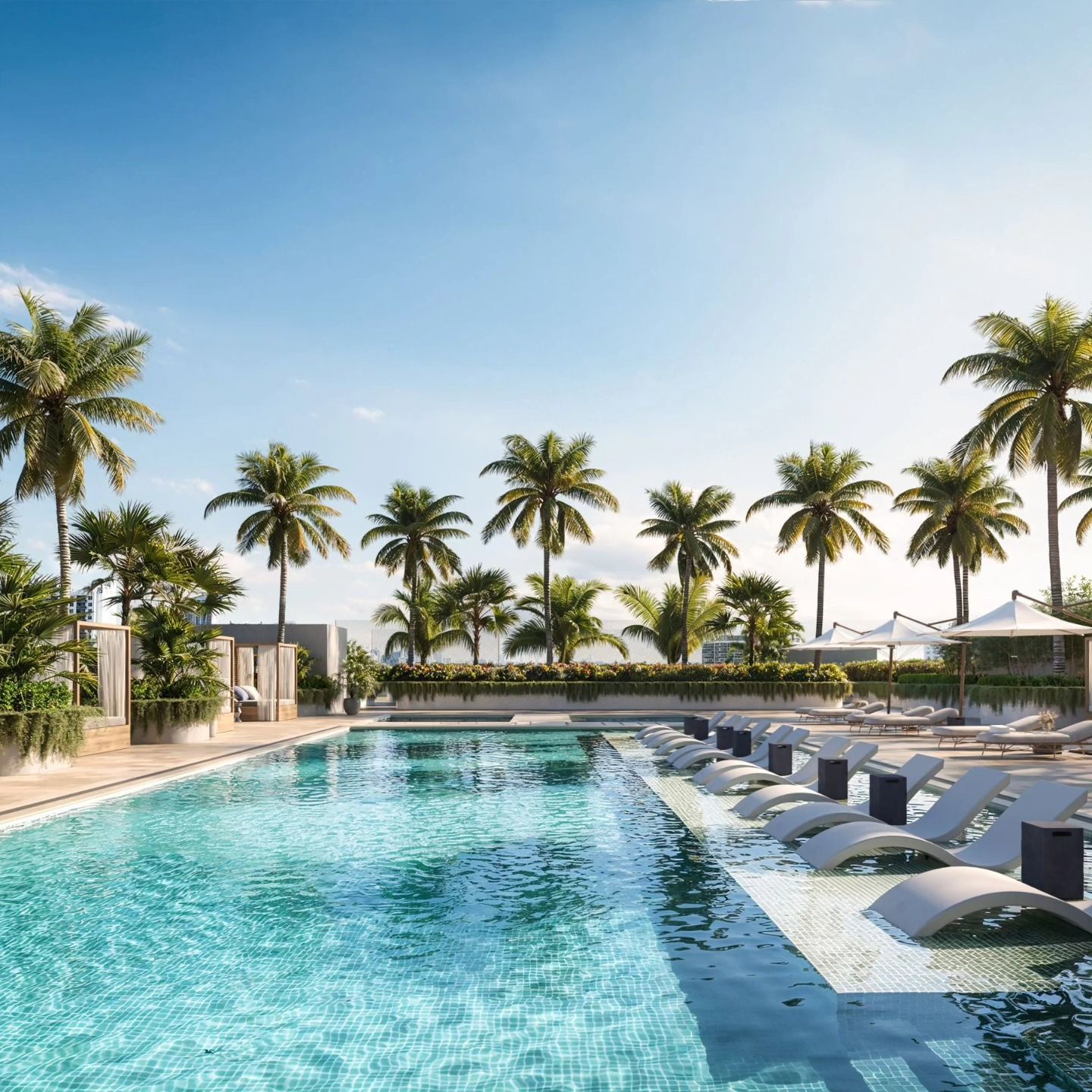Palm-lined resort pool with blue water, lounge chairs, and a sunny sky