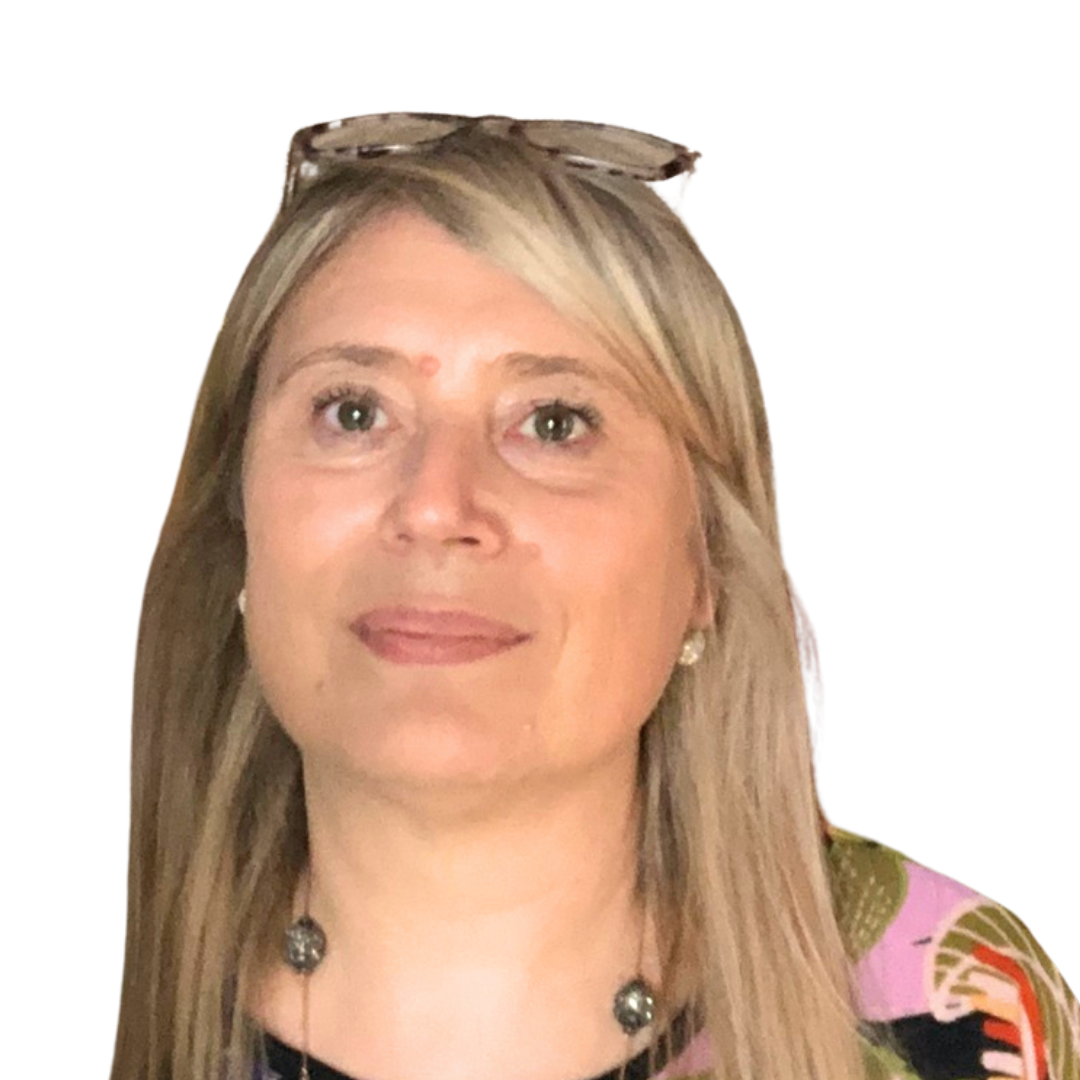 Une femme portant des lunettes de soleil et un collier sourit à la caméra.