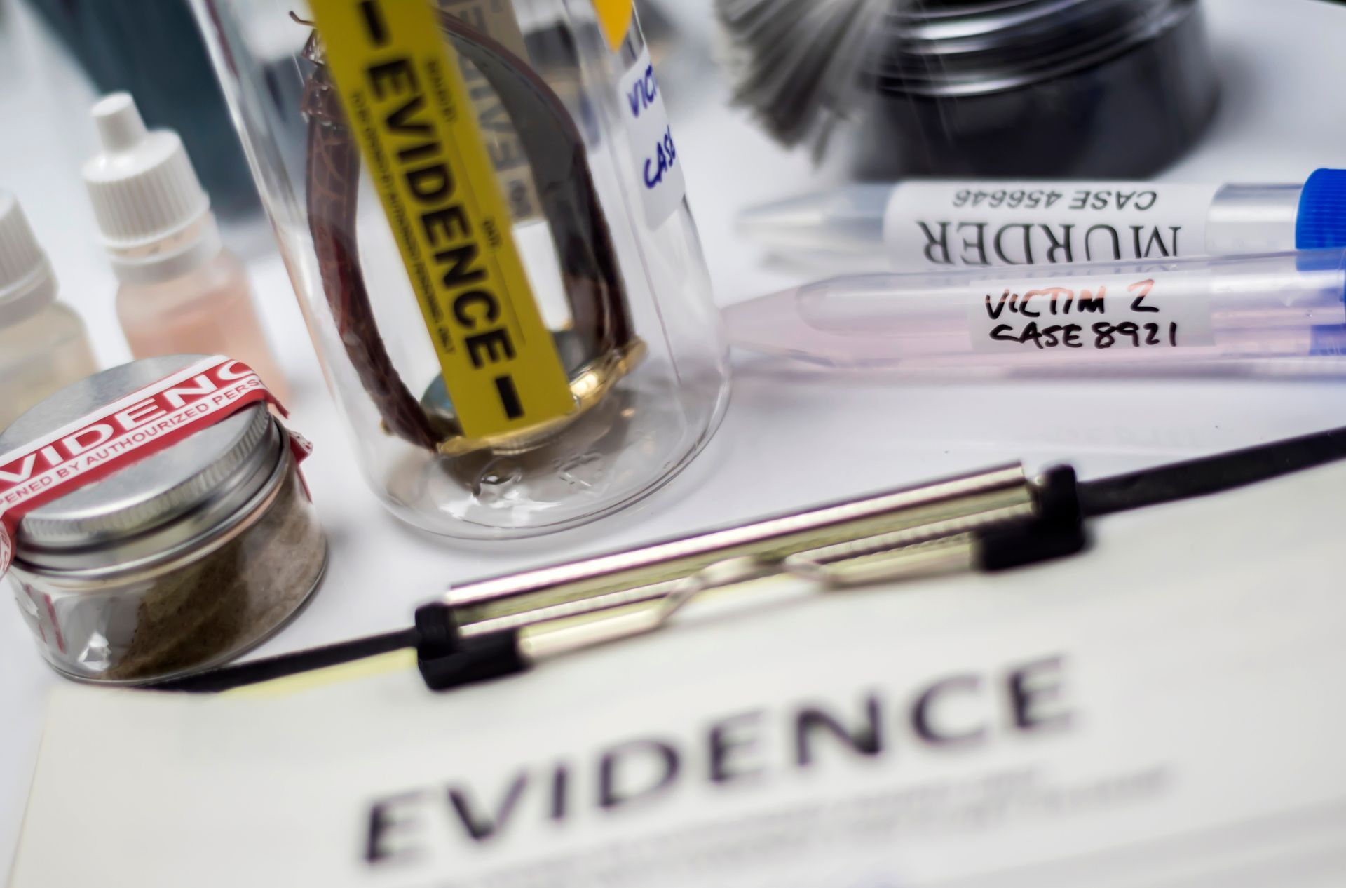 Close-up of crime scene evidence; jar with bracelet, vials marked