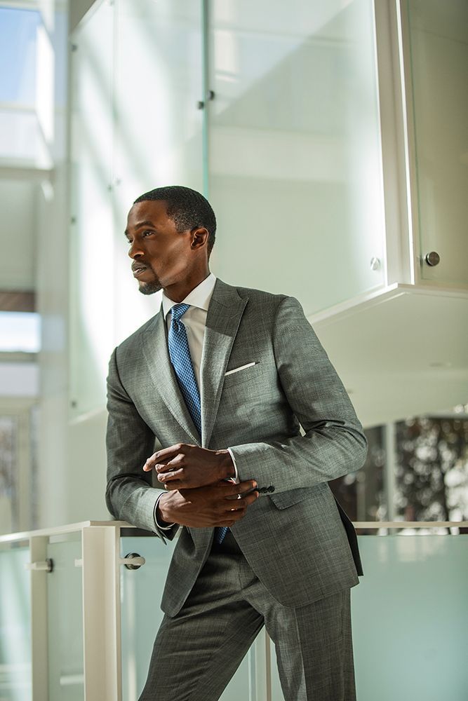 a man in a suit and tie is standing on a staircase .