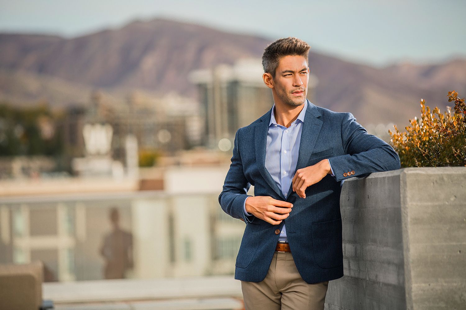 a man in a suit is leaning against a wall .