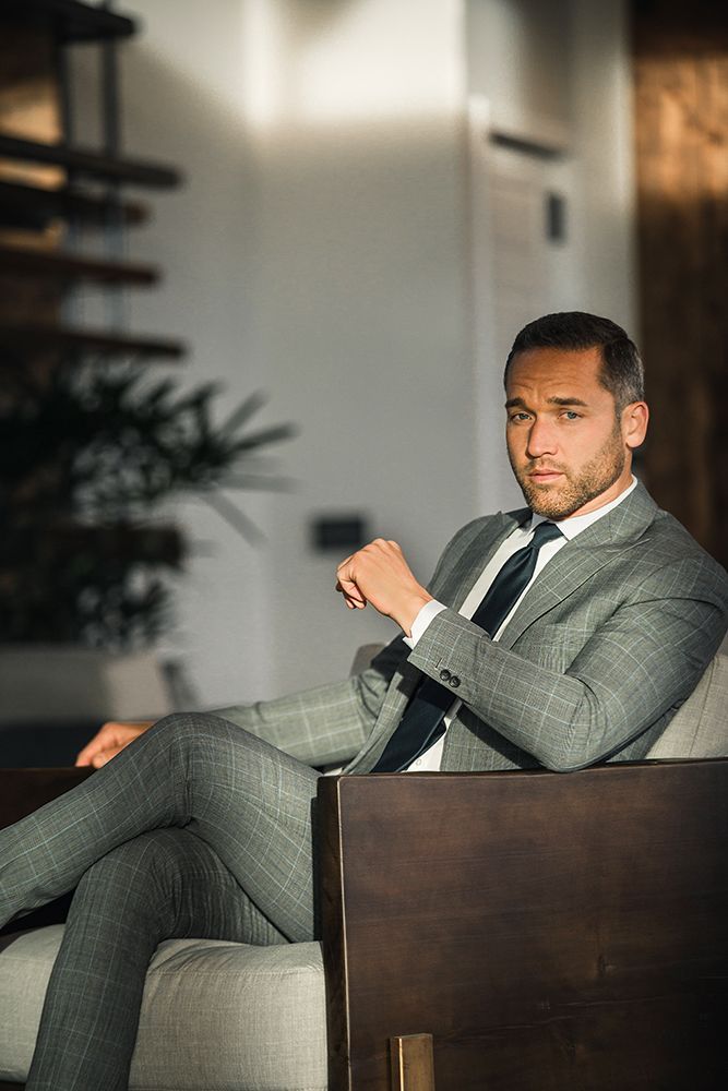 A man in a suit and tie is sitting in a chair.