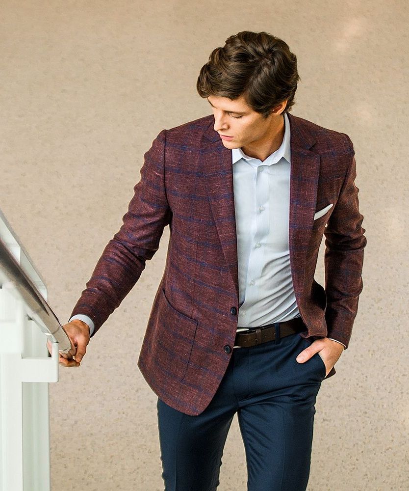 a man wearing a purple jacket and blue pants is standing on a set of stairs .