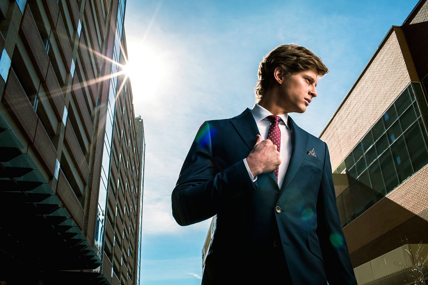 A man in a suit and tie is standing in front of a building.
