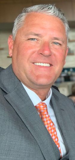 A man in a suit and tie is smiling for the camera.