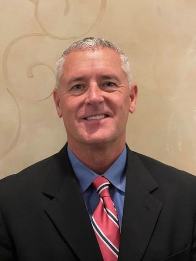 A man in a suit and tie is smiling for the camera.