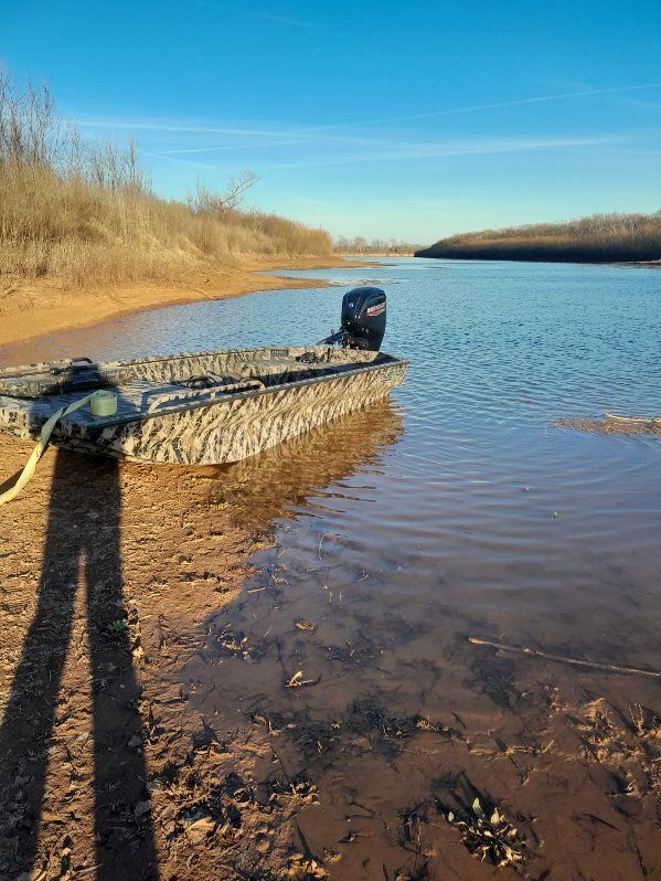 A boat is docked on the shore of a lake.