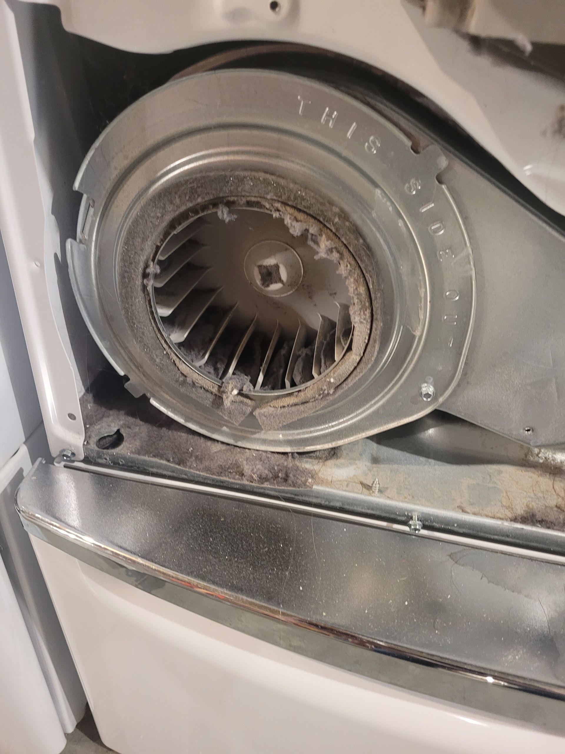 Close-up of a dusty circular car air vent with metallic trim and black slats