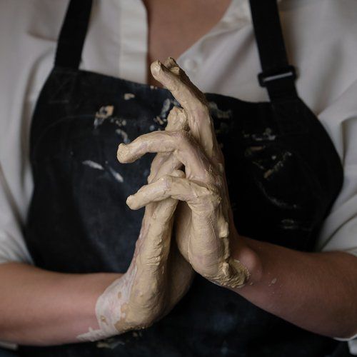person with clay on their hands
