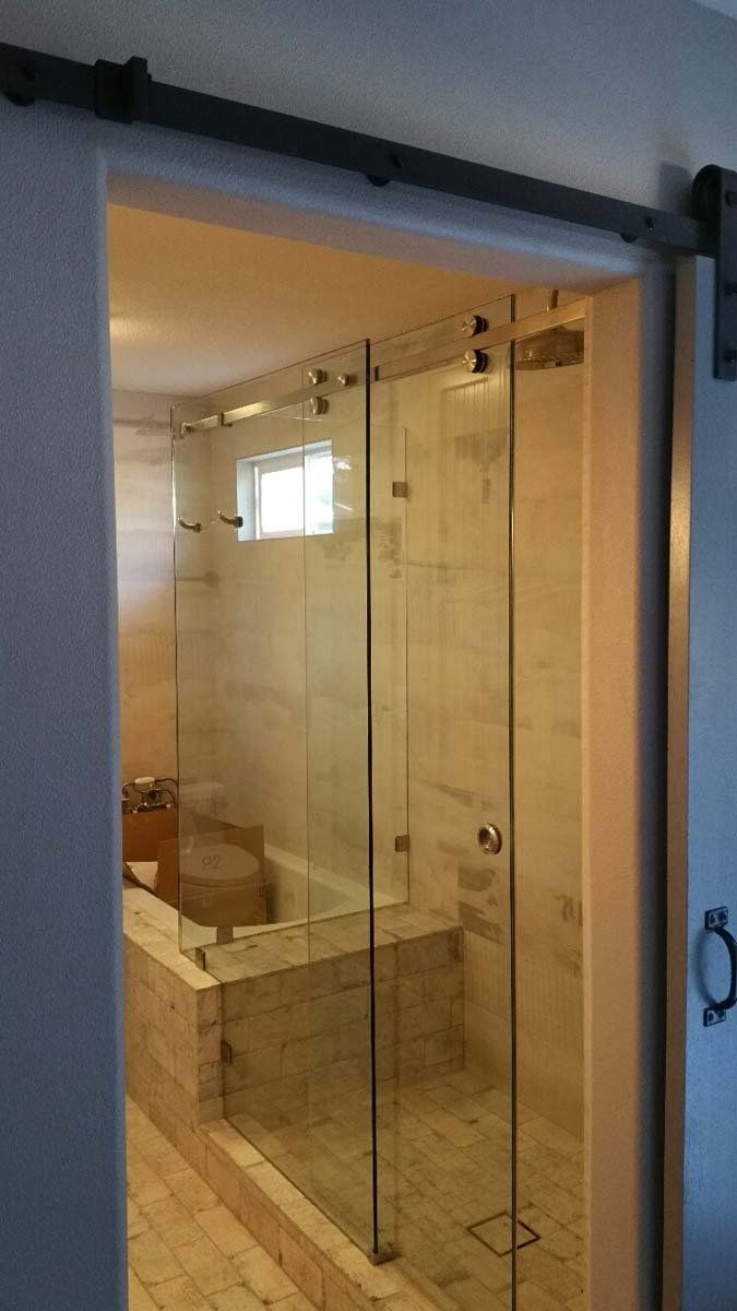 Glass shower with a sliding door, inside a bathroom.