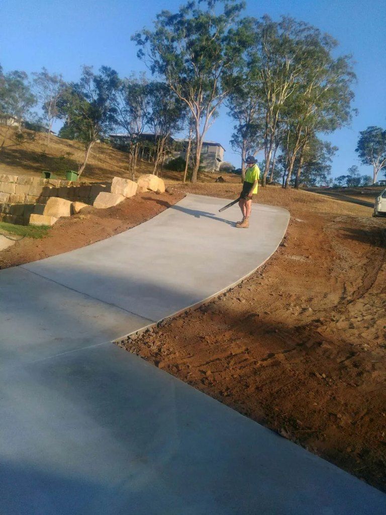 Man in High-vis Vest Using a Leaf Blower on a Concrete Path — Comet Concreting in Drayton, QLD