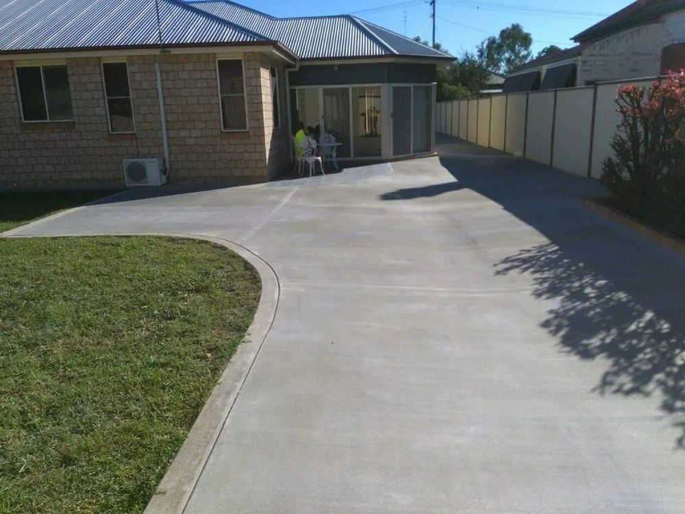 Concrete Driveway Curves Past Lawn Toward a House — Comet Concreting in Drayton, QLD
