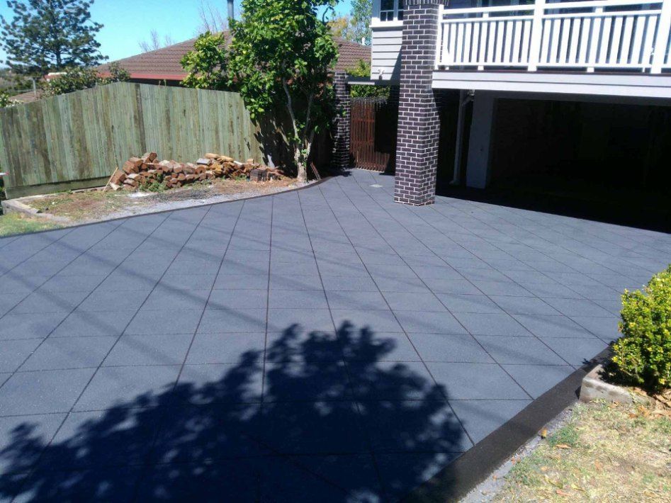 Dark Gray Interlocking Tiles Cover a Driveway — Comet Concreting in Drayton, QLD