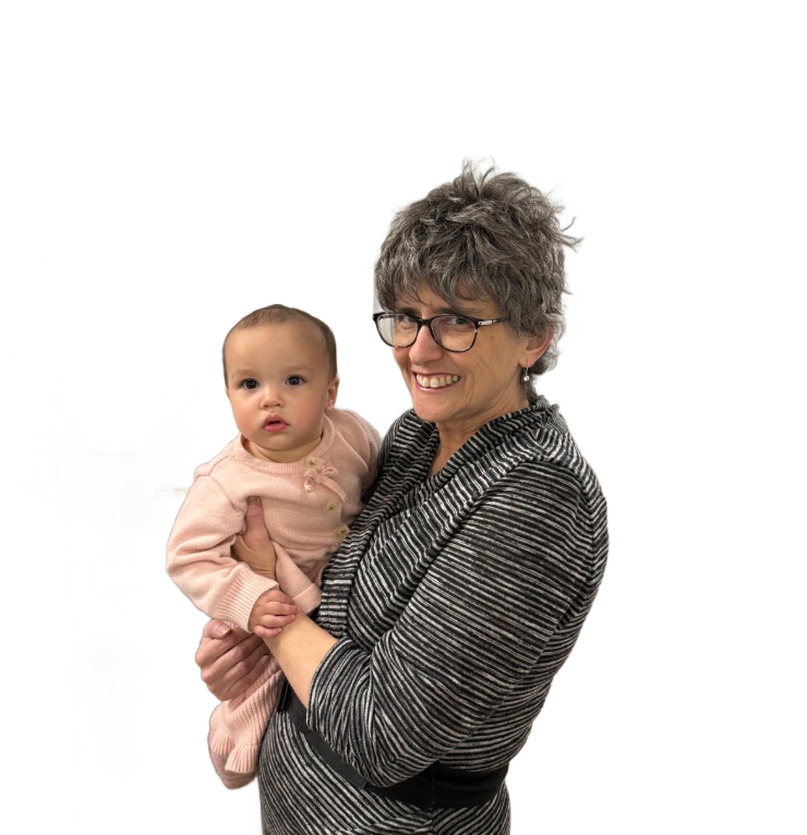 Woman in glasses holding a baby, both smiling. The baby wears pink. They are against a white background.