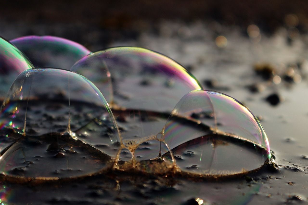 bubbles are floating in a puddle on the ground.