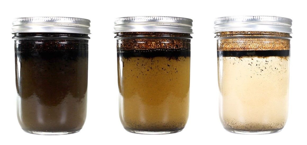Three jars filled with emulsified oil and water at different stages of separation