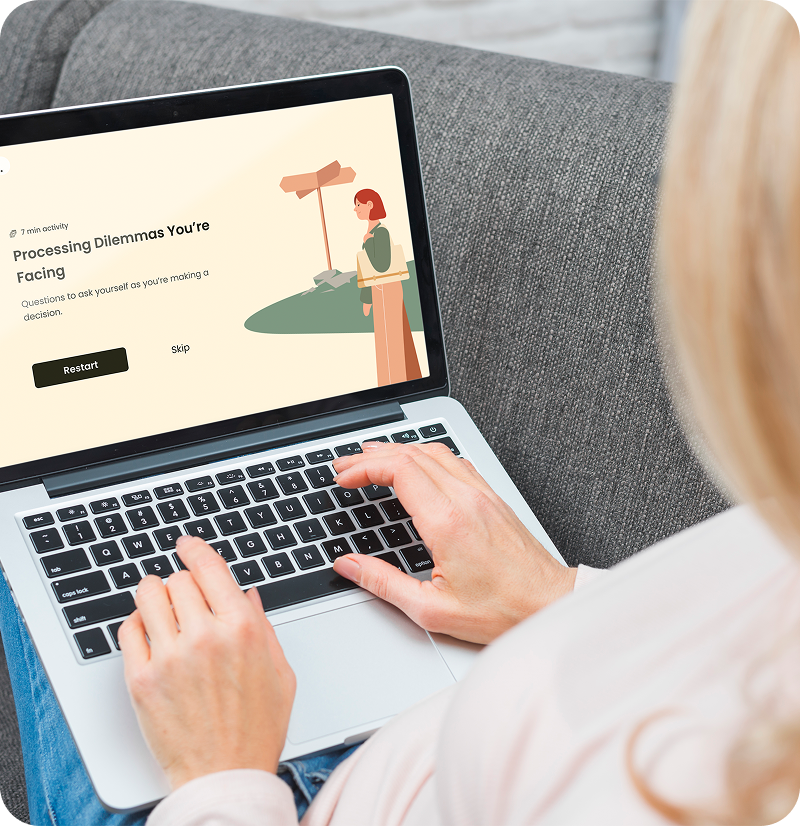 Woman using laptop on a couch, displaying webpage: 