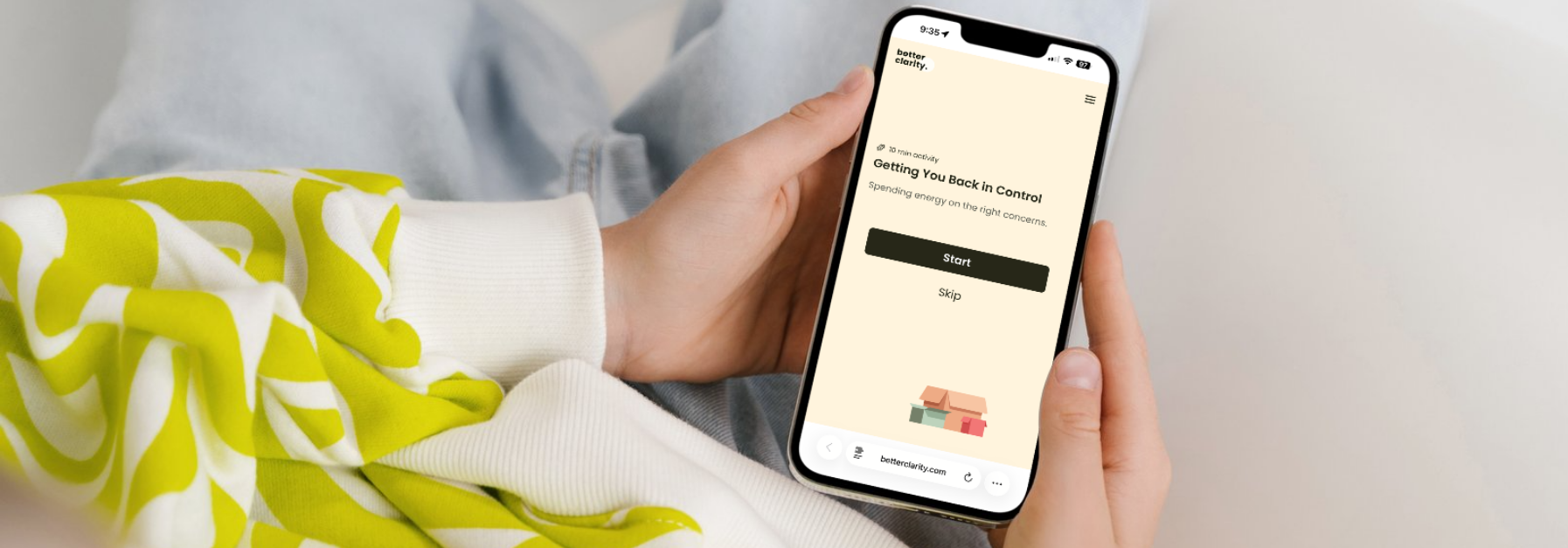 A person wearing a lime green and white patterned sweater holds a smartphone displaying a mobile app interface.