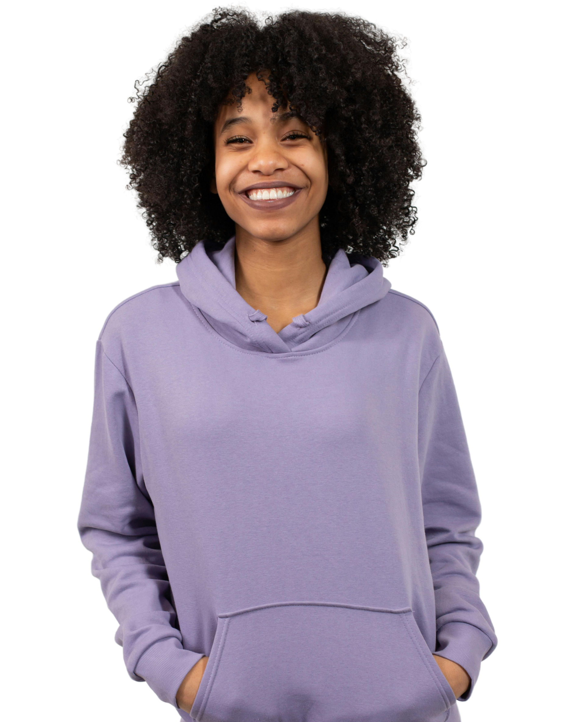 Woman with long brown hair smiles, wearing a striped shirt and arm tattoo.