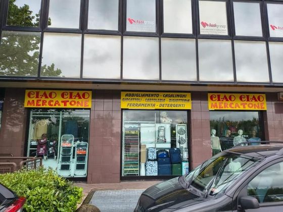Two cars are parked in front of a store called ciao ciao mercatone