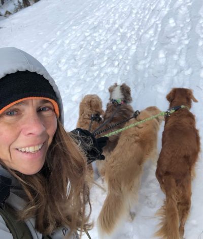 Kristen taking a selfie with a group of dogs