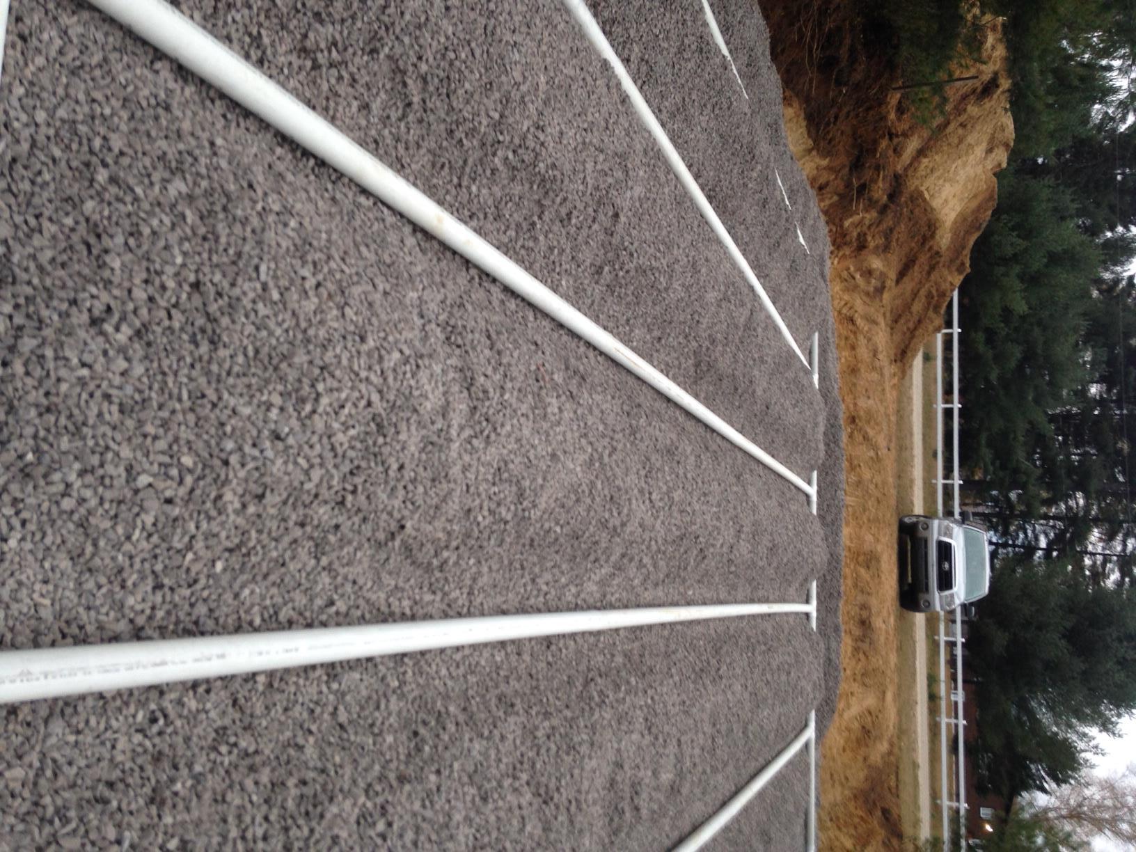 A car is parked on the side of a gravel road