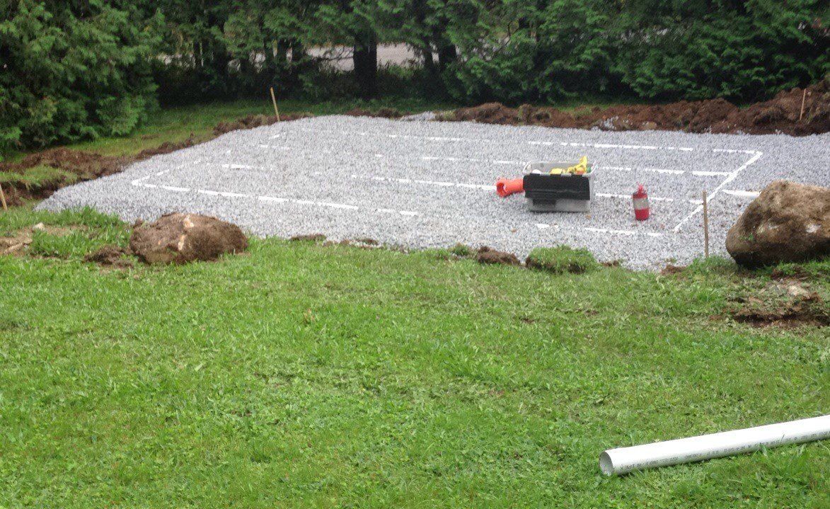 A lawn with a gravel area in the middle of it.