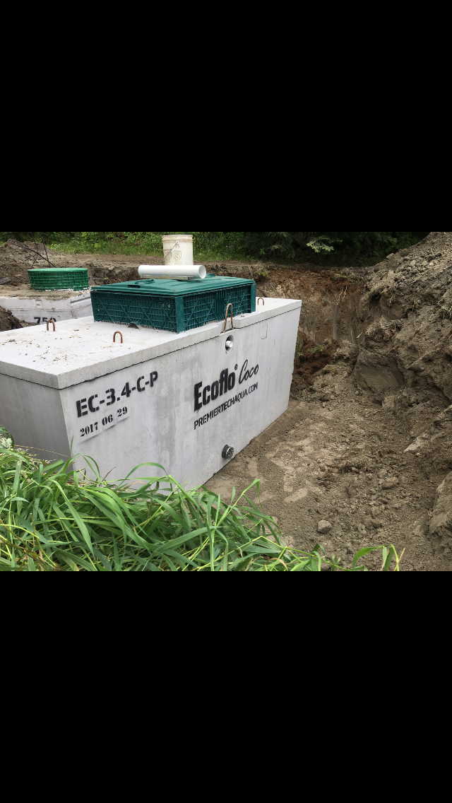 A septic tank is sitting in the middle of a dirt field.