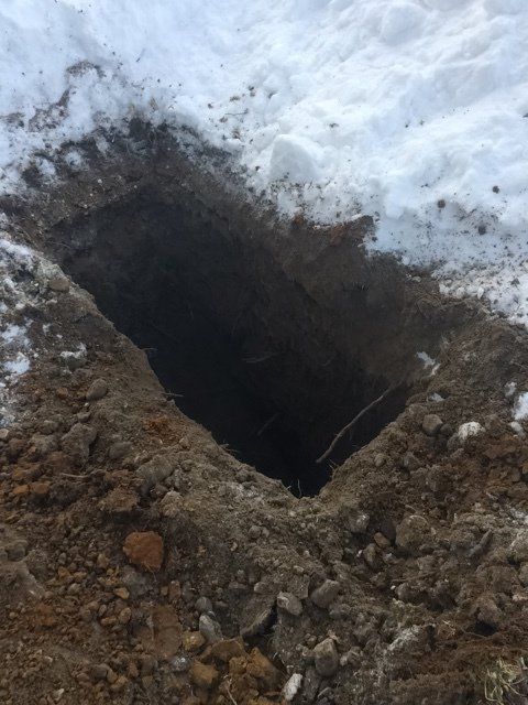 There is a hole in the ground in the snow.