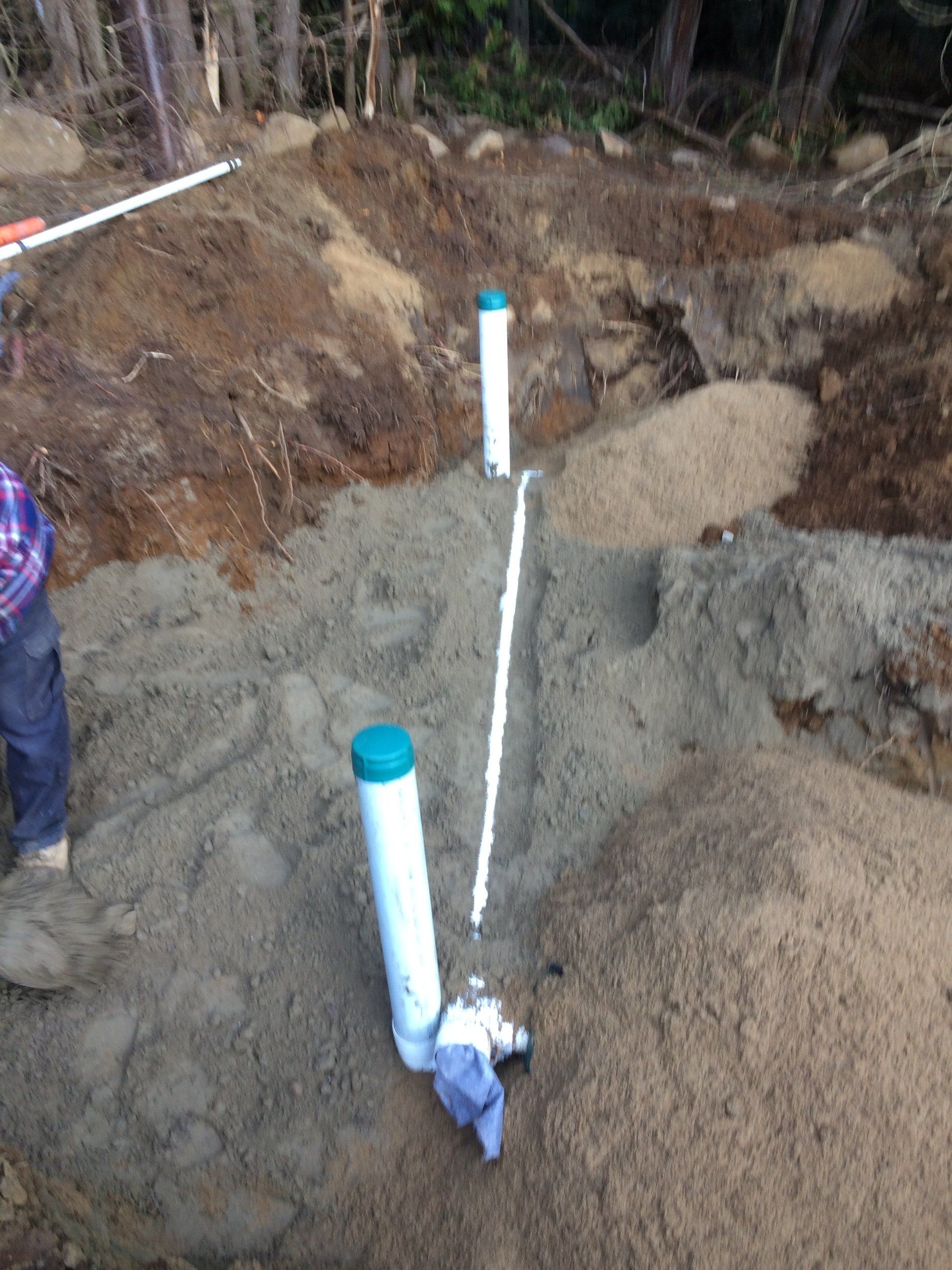 A man is digging a hole in the dirt with a shovel.