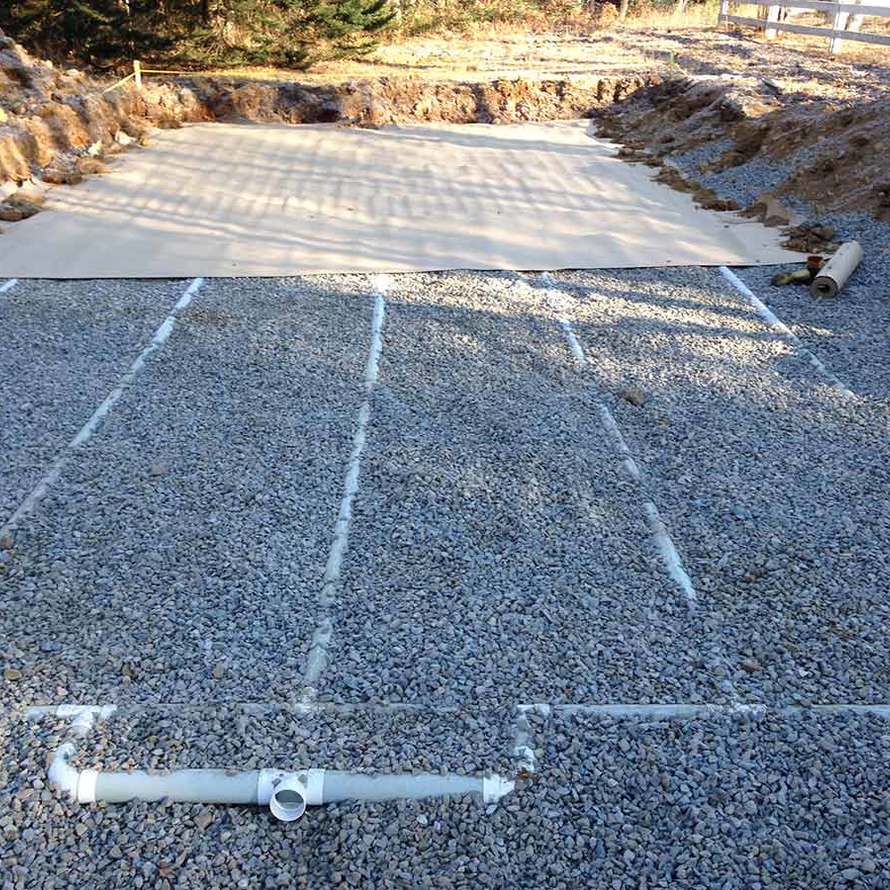 A pile of gravel with a pipe in the middle of it.