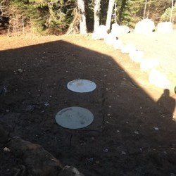 Deux fosses septiques sont posées sur un terrain vague.