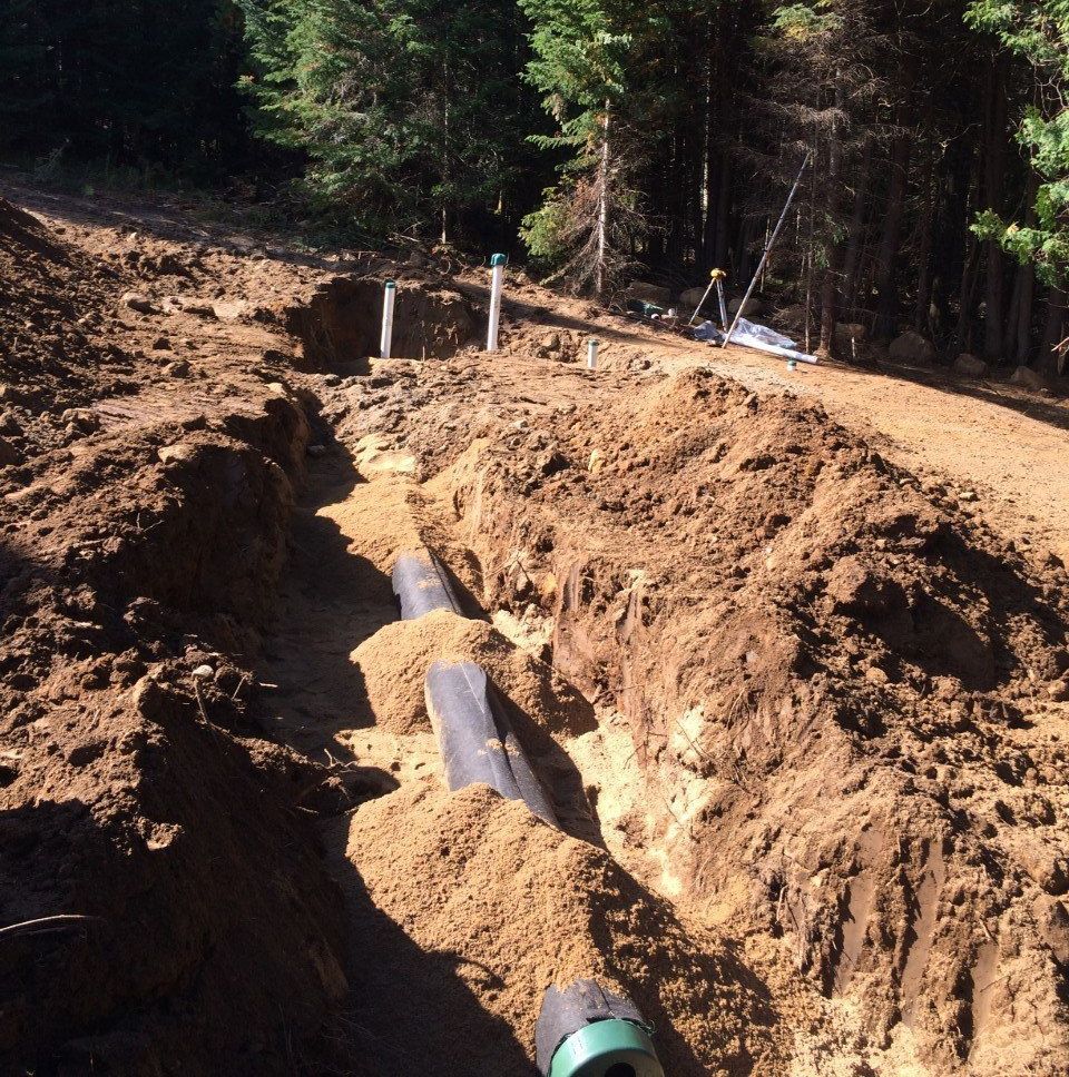 Un trou dans le sol avec un tuyau vert dedans