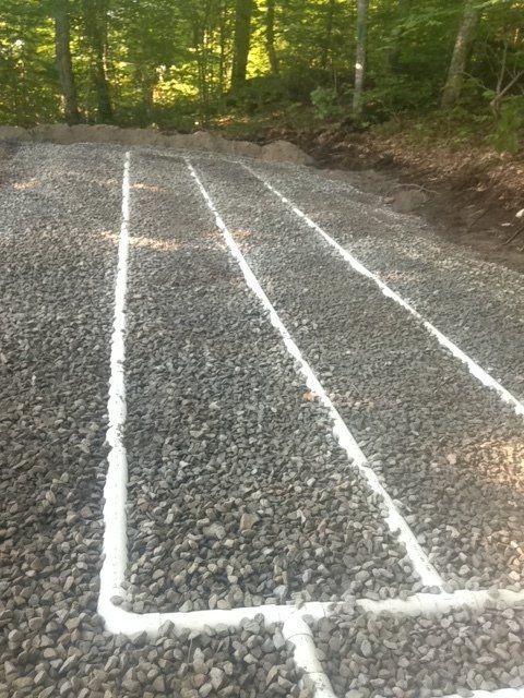 A gravel road with white lines on it and trees in the background.