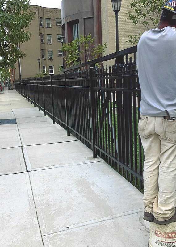Man is Standing Next to a Fence — Clifton, NJ — All Jersey Fence Co.