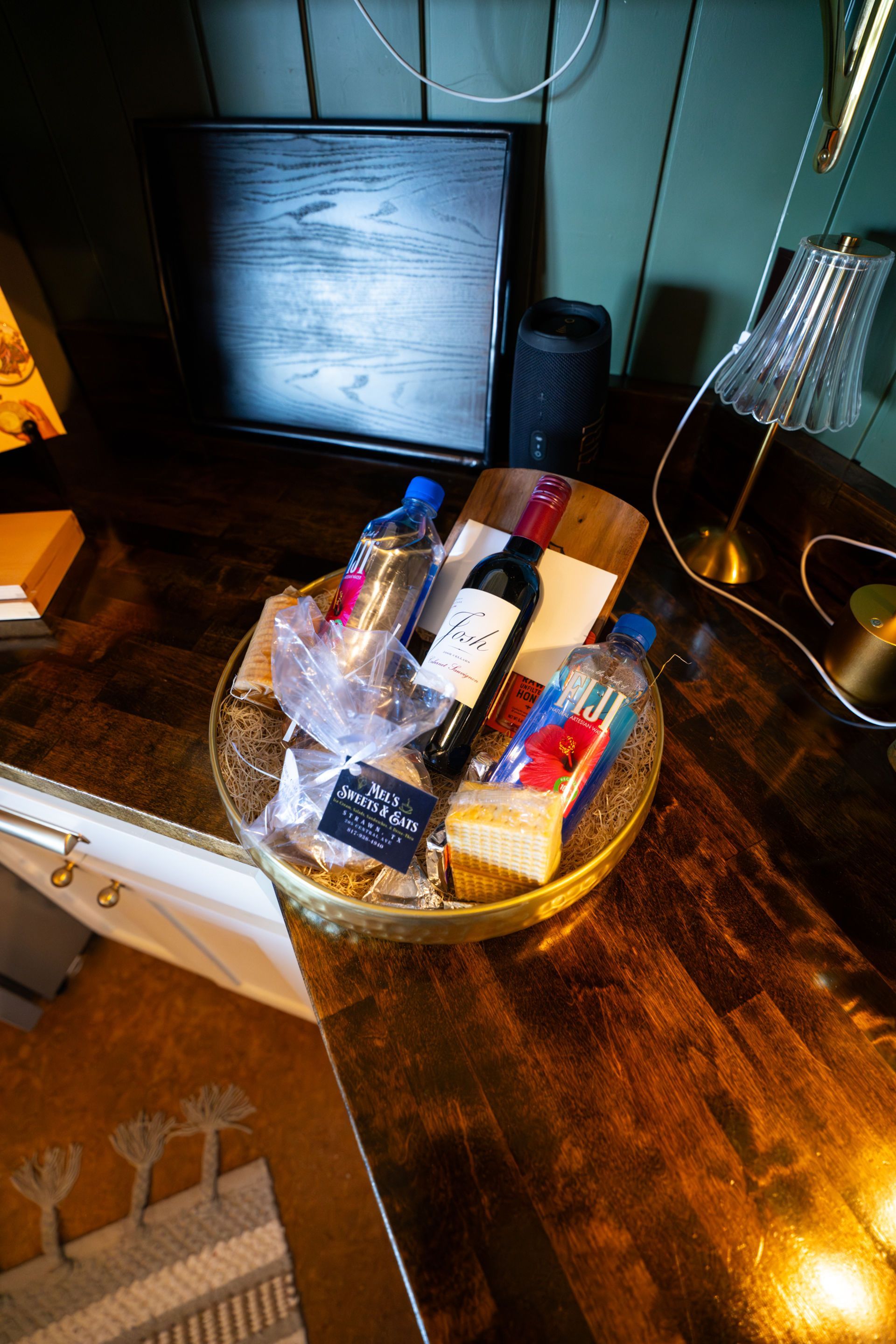 Couple picnicking on a cliff overlooking a river. Sunlight, trees, and rocky terrain are visible.