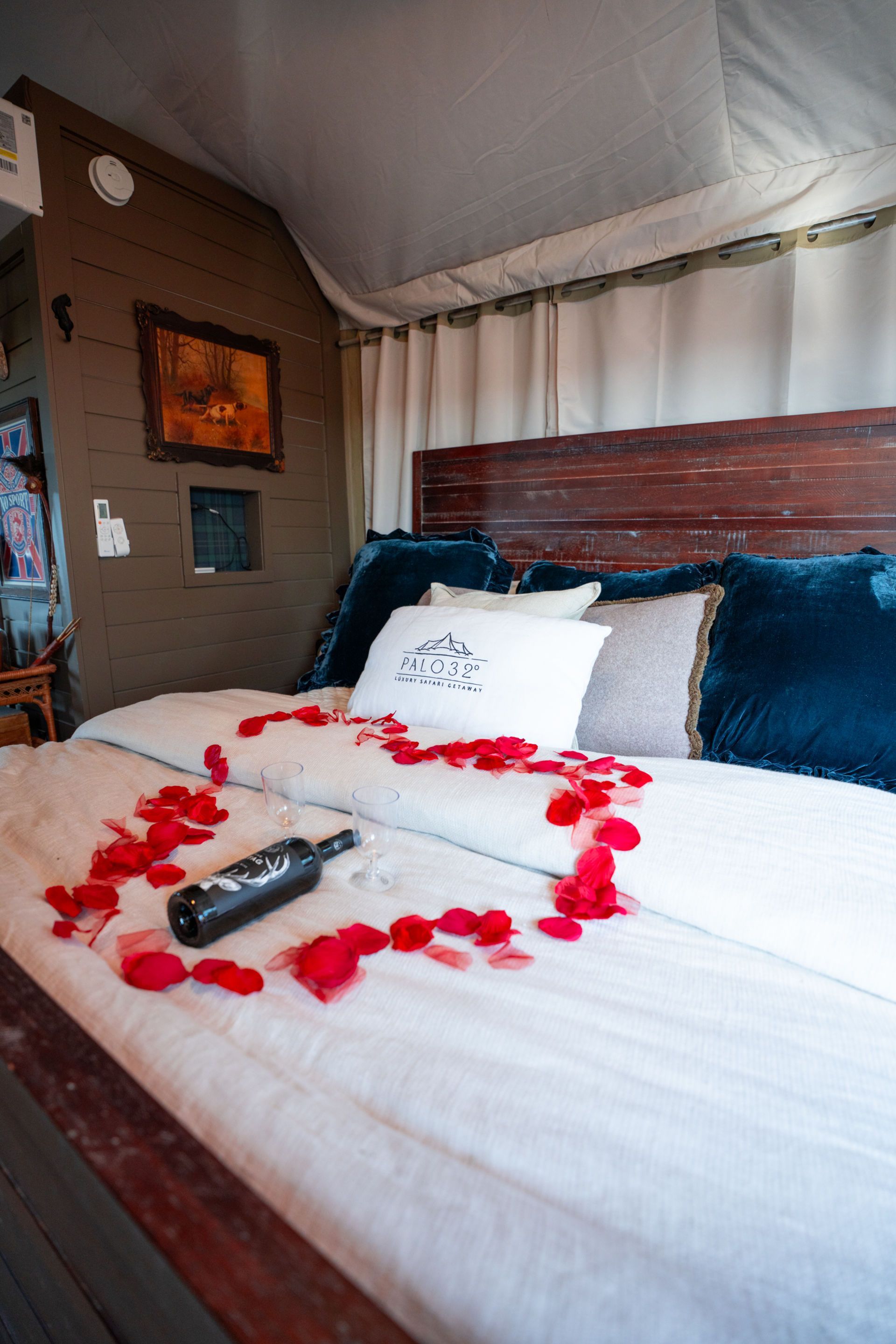 Off-road SUV driving on a dirt road, kicking up dust in front of a tree line.