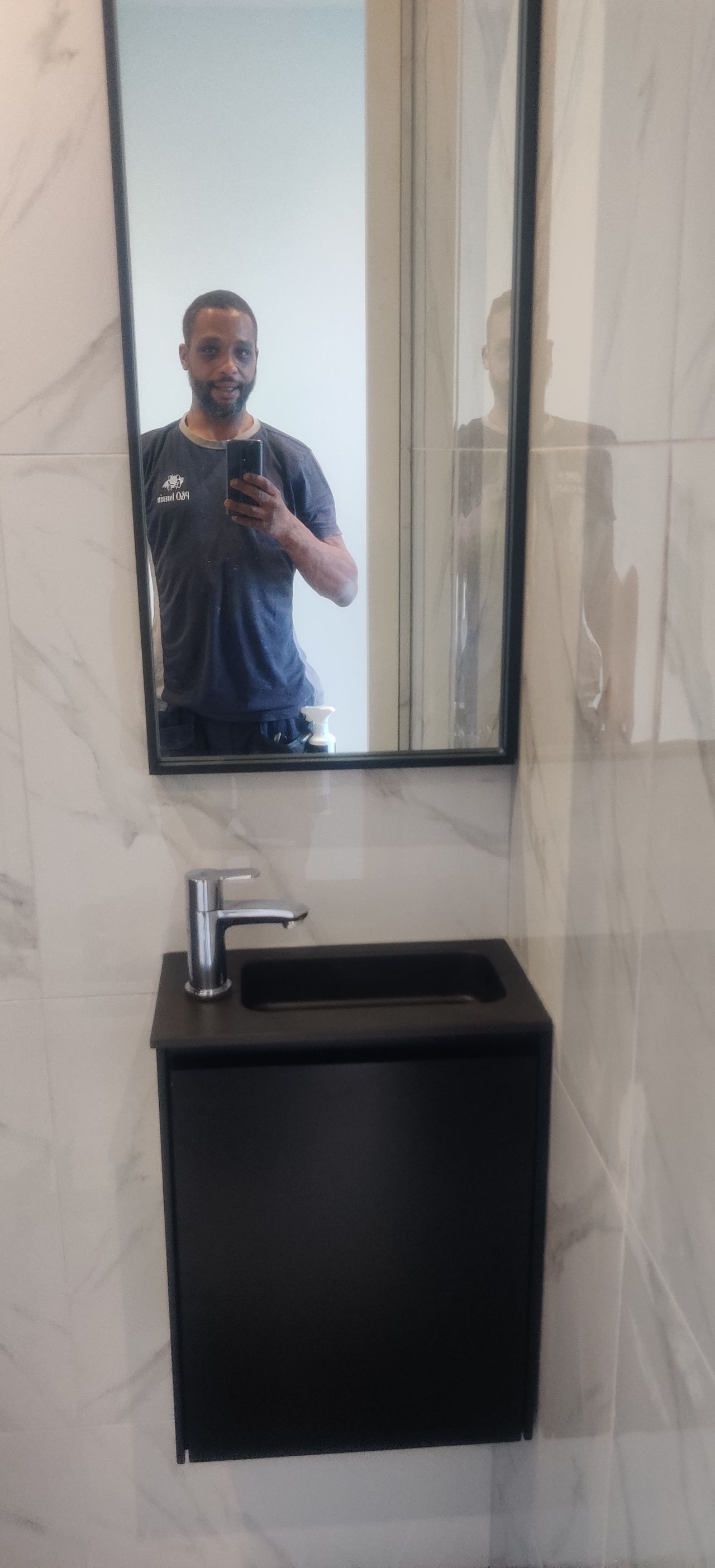 A man is taking a picture of himself in a bathroom mirror.
