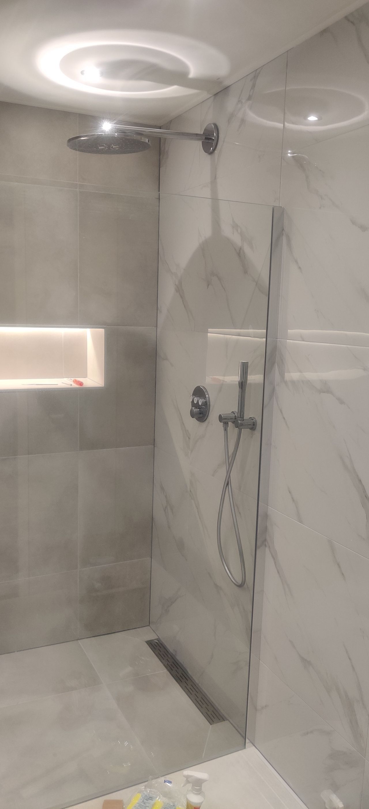 A bathroom with a walk in shower and a shower head.