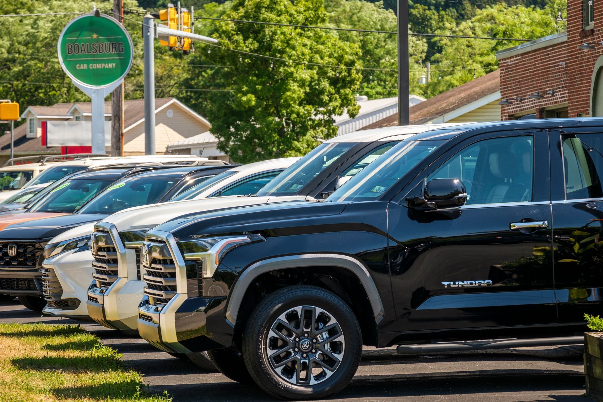 Black Toyota Tundra truck parked in a row of cars outside of a car dealership on a sunny day. | Boalsburg Car Co.