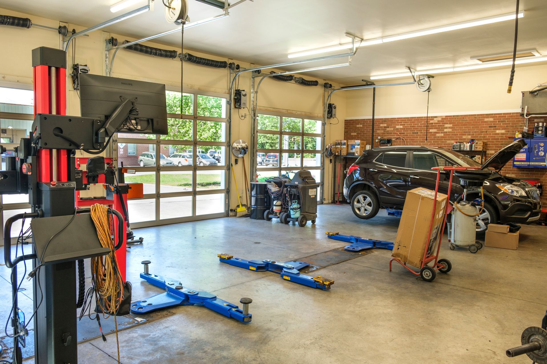 Car repair shop interior, with a car on a lift and tools scattered around. | Boalsburg Car Co.