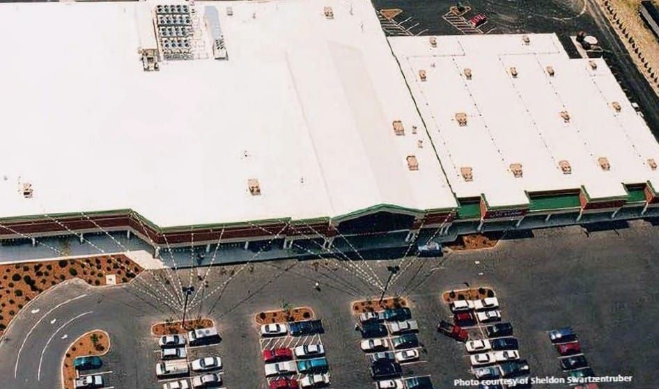 An aerial view of a large building with cars parked in front of it
