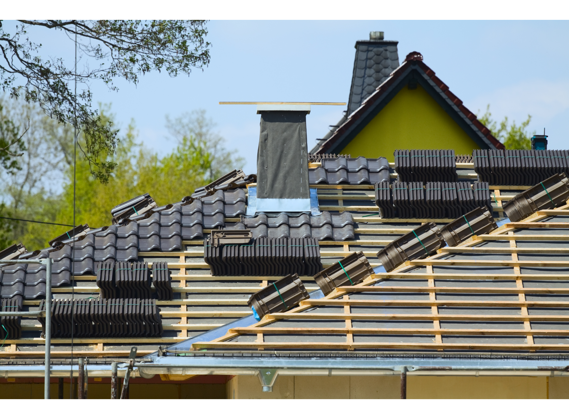 The roof of a house is being built and the tiles are being installed.