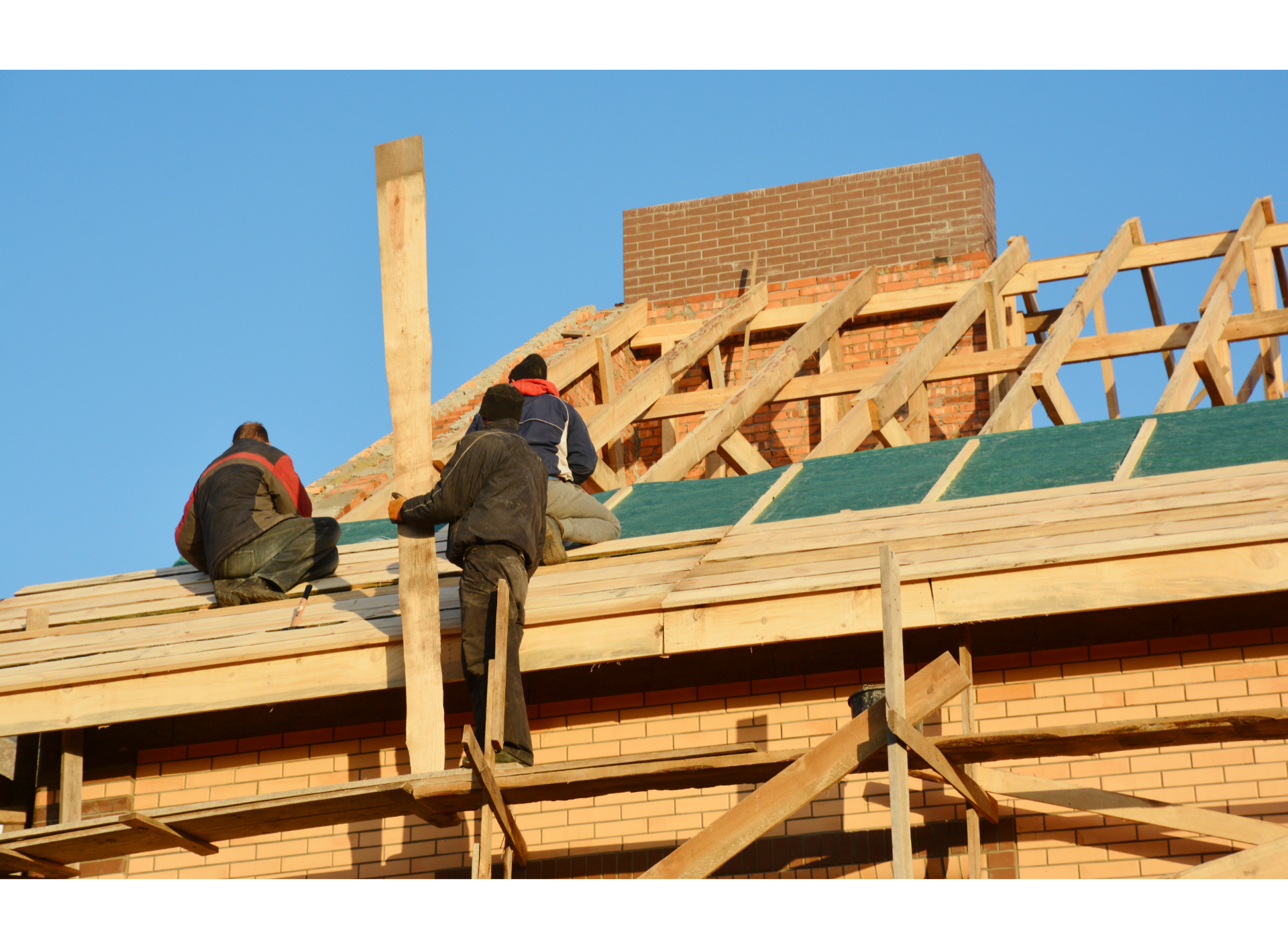 A group of men are working on the roof of a building.