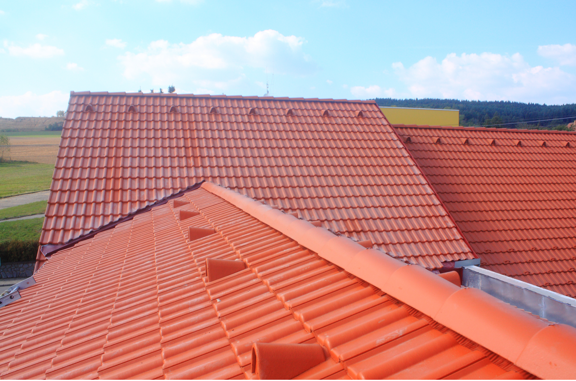 A red tiled roof with a blue sky in the background