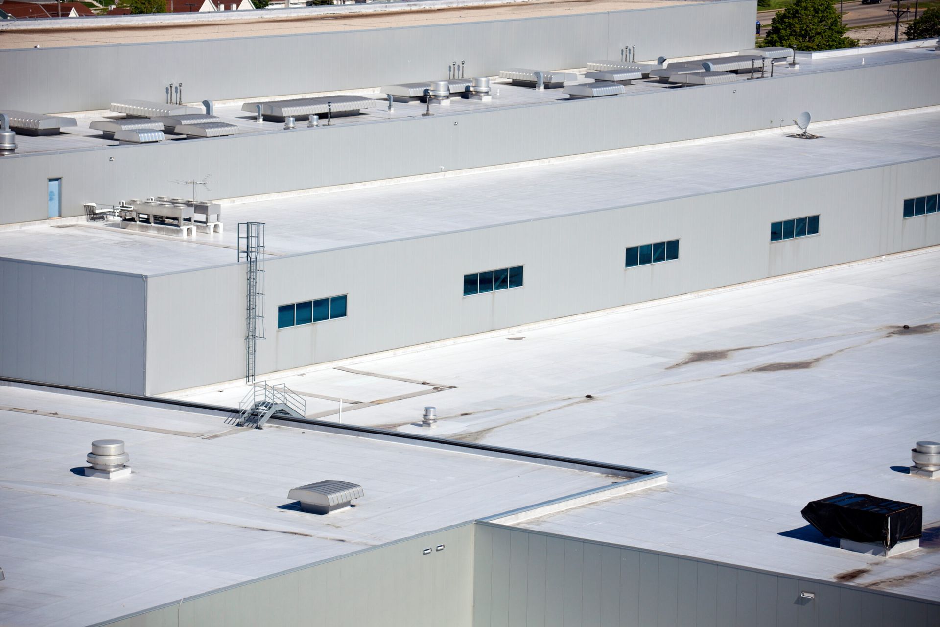 An aerial view of a large building with a white roof.