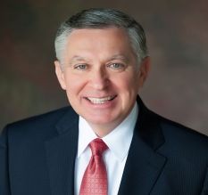 A man in a suit and tie is smiling for the camera.