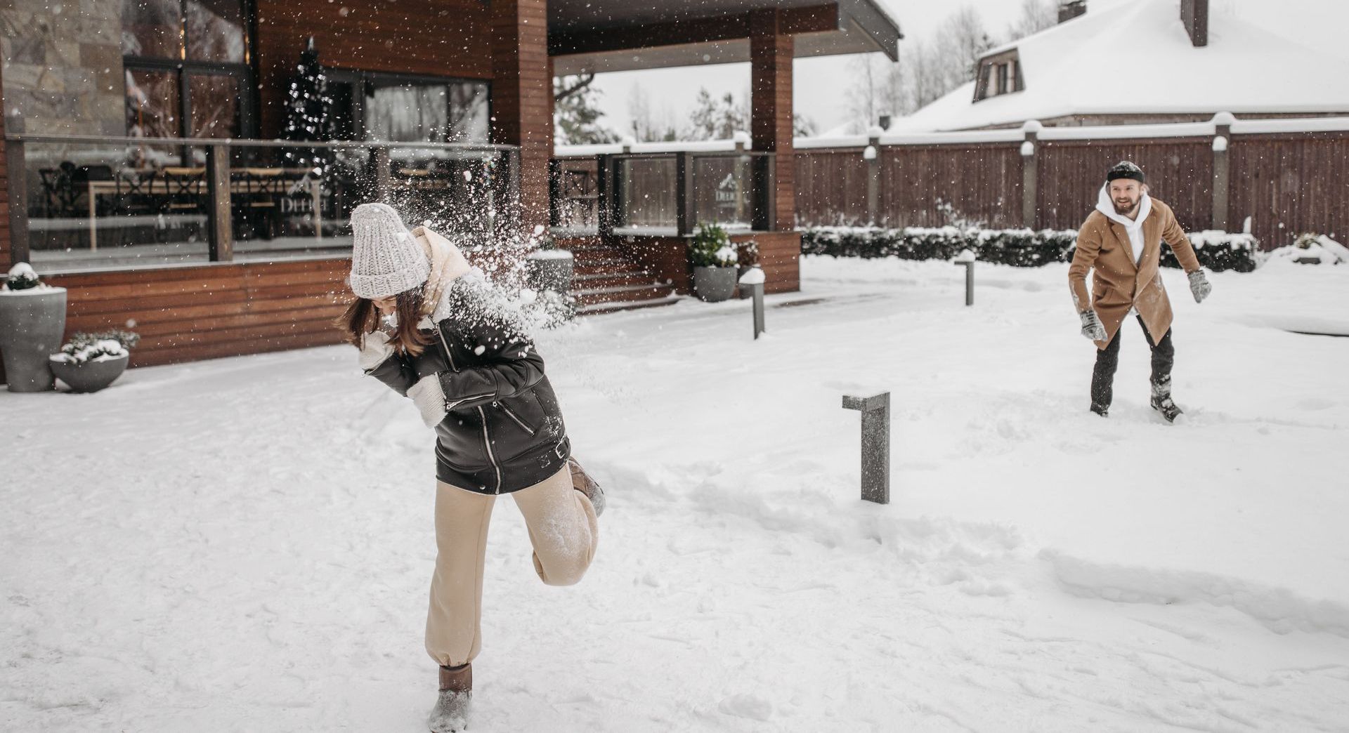 man and woman having snowball fight