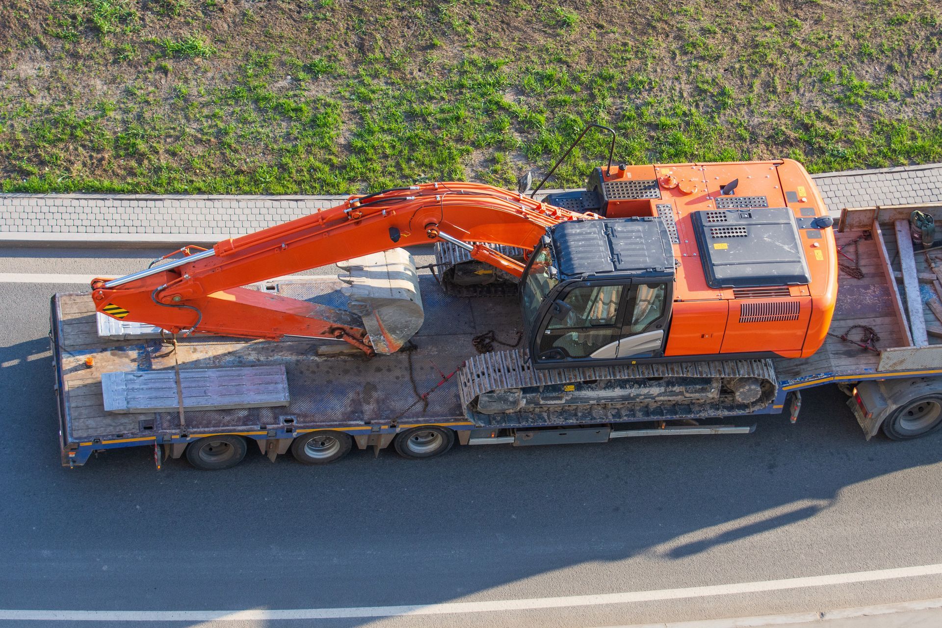 Orange Excavator on a Flatbed Trailer, Roadside — Downs Towing & Recovery Service in St. George, QLD
